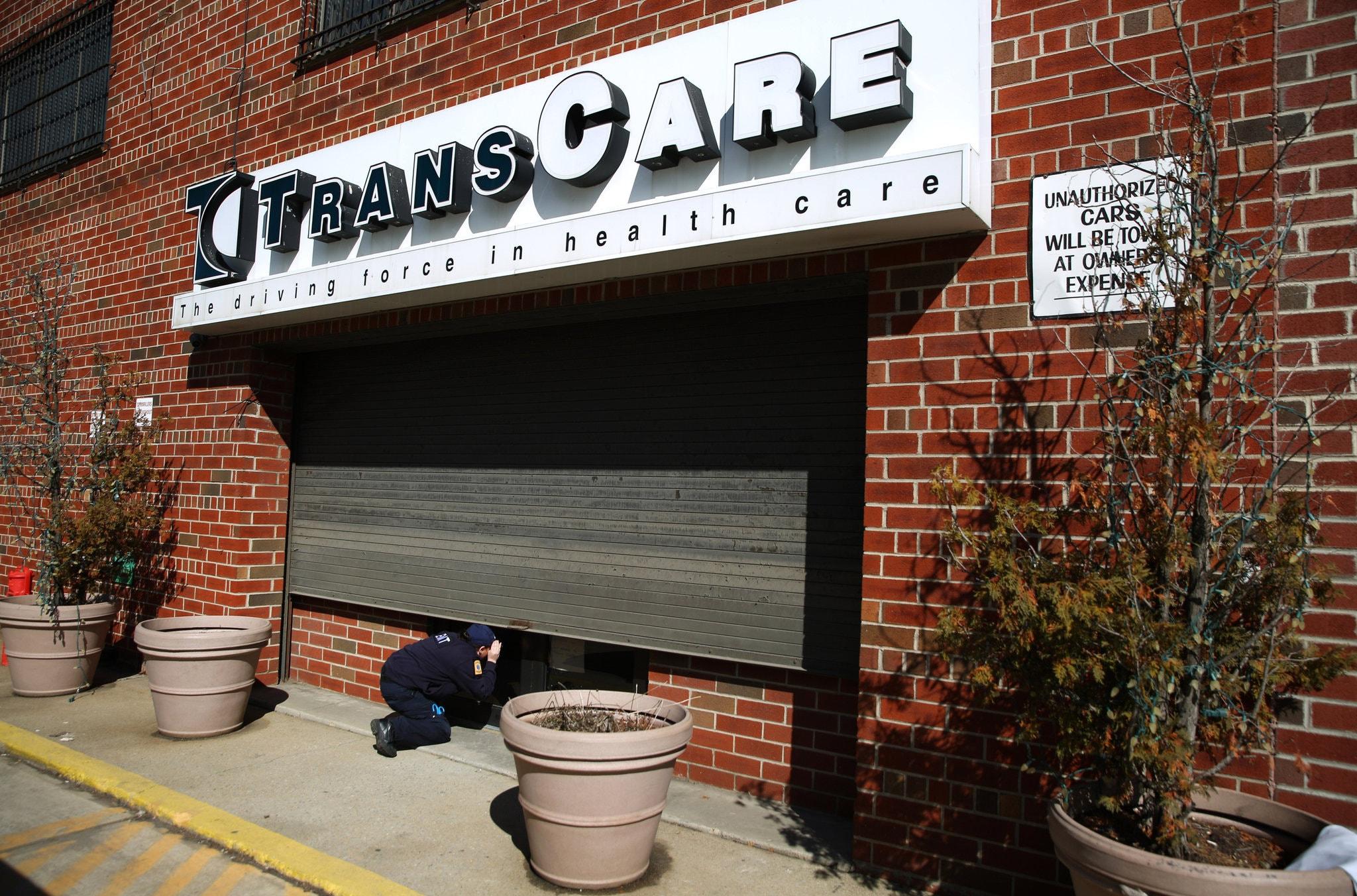 Jessica Perez, an emergency worker at TransCare EMS, peeking inside the company’s closed offices in Brooklyn in February.